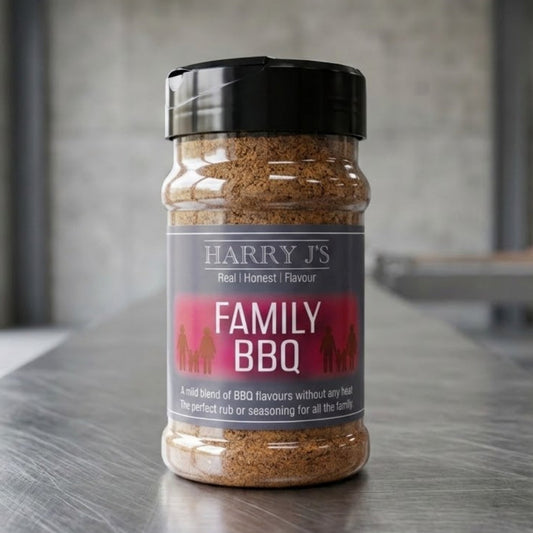 A jar of Harry's Family BBQ seasoning stands on a stainless steel counter in a modern kitchen setting with a blurred concrete wall and window in the background.